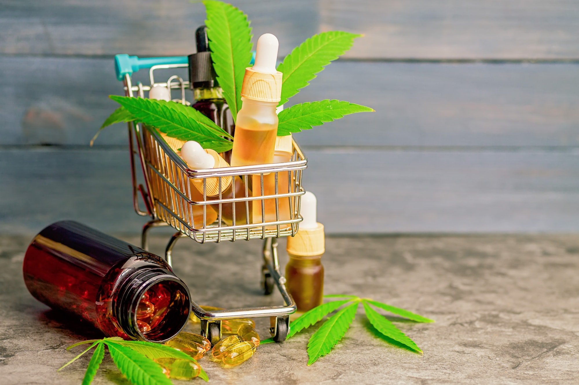 Supermarket trolley basket with cannabis Cbd oils capsules, CBD purchasing concept